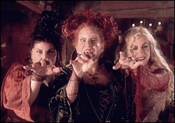 An animated GIF from Hocus Pocus showing the Sanderson Sisters—Mary (Kathy Najimy), Winifred (Bette Midler), and Sarah (Sarah Jessica Parker)—reaching their clawed hands toward the camera with menacing grins.