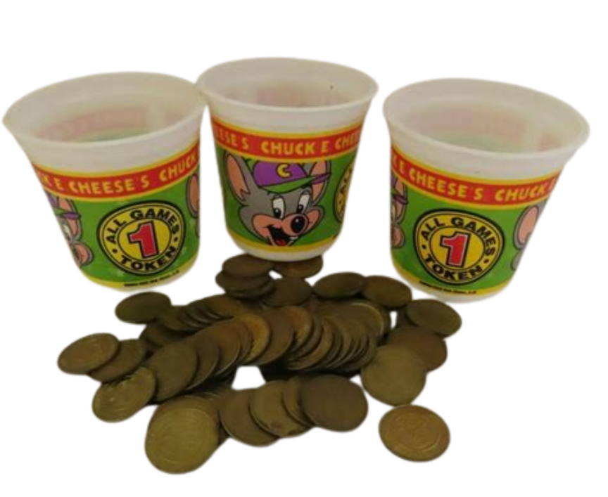 Three vintage plastic Chuck E. Cheese token cups sitting behind a sprawling pile of brass game tokens—the sacred currency of Friday night birthday parties and ticket-redemption sprees.