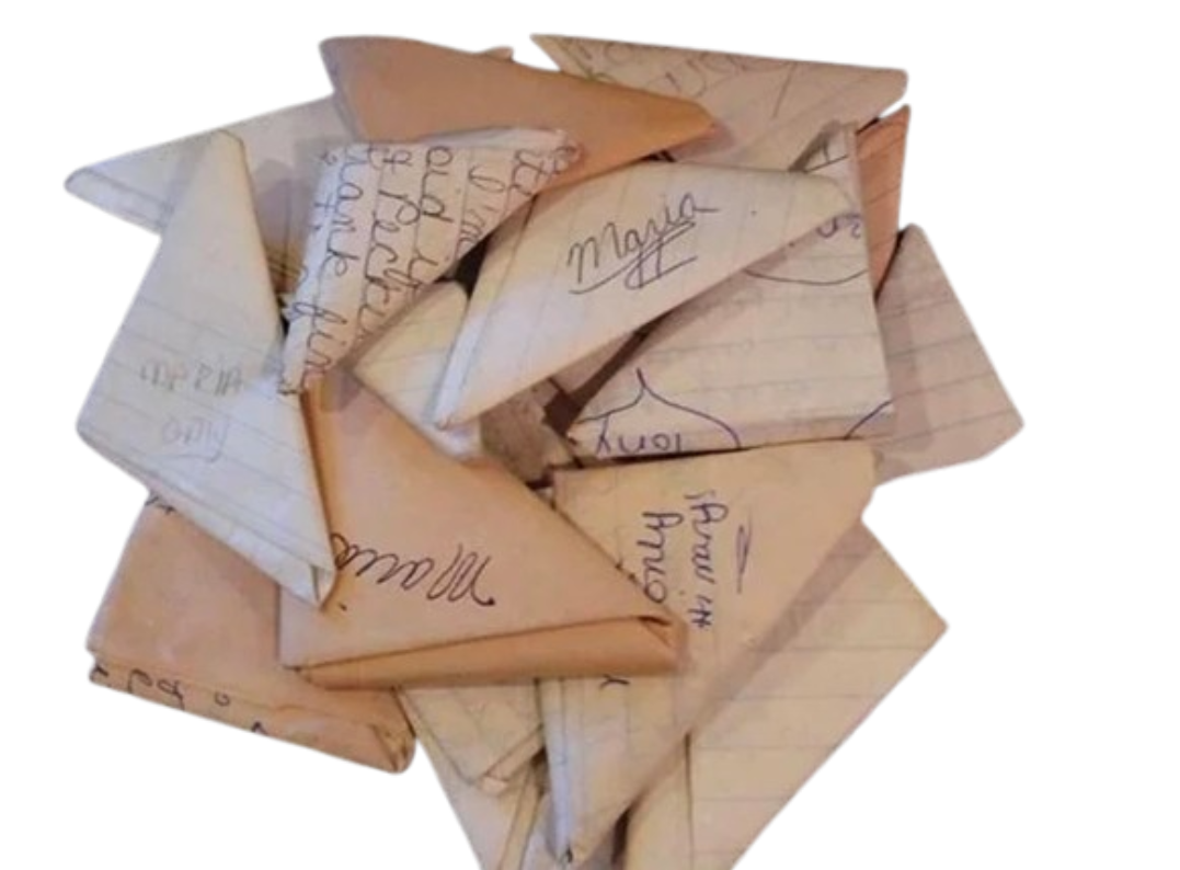 A stack of handwritten classroom notes folded into tight origami paper footballs—the primary medium for passing secrets and kicking field goals across study hall desks.