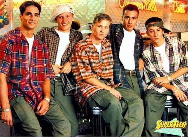 The Backstreet Boys posing in oversized button-down plaid flannel shirts, baggy olive cargo pants, and backwards caps for a classic 90s teen magazine poster.