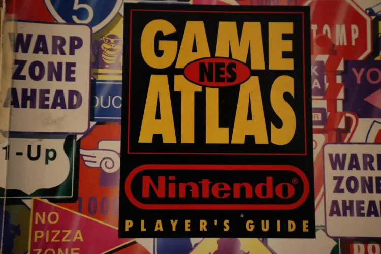 Picture showcasing the iconic NES Game Atlas cover by Nintendo Power, packed with retro street-sign graphics pointing toward warp zones and 1-Up mushrooms—the ultimate holy grail bible for 8-bit map lovers.