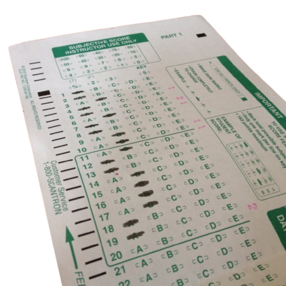 A green Scantron 882-E multiple-choice test sheet filled out with dark #2 pencil marks—the dreaded gatekeeper of pop quizzes and midterms that punished light erasures.