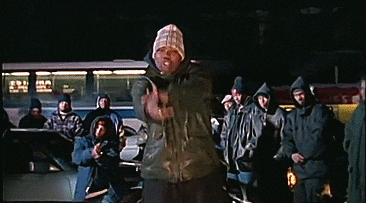 An animated GIF from Wu-Tang Clan's "C.R.E.A.M." music video showing Method Man rapping in a heavy parka and beanie surrounded by the crew on a cold Staten Island night.