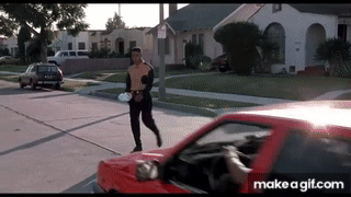 An animated GIF from Boyz n the Hood showing Ricky Baker (Morris Chestnut) crossing a sunny residential street with a football before getting cut off by a red car, driving the tension right before the tragedy.