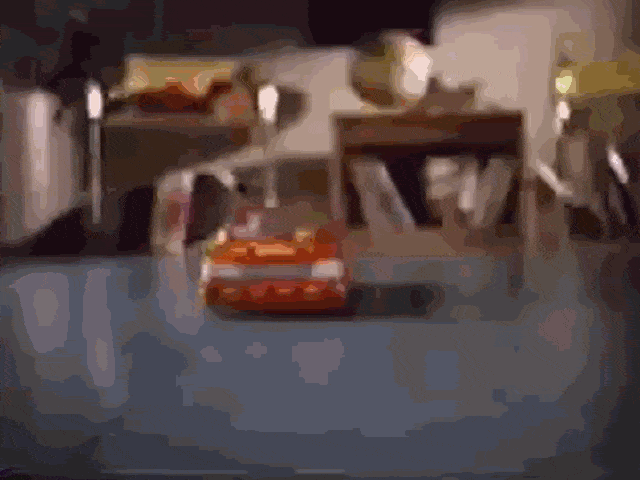 An animated GIF from a 90s Crash Dummies TV commercial showing a toy car speeding down a track toward a wall.