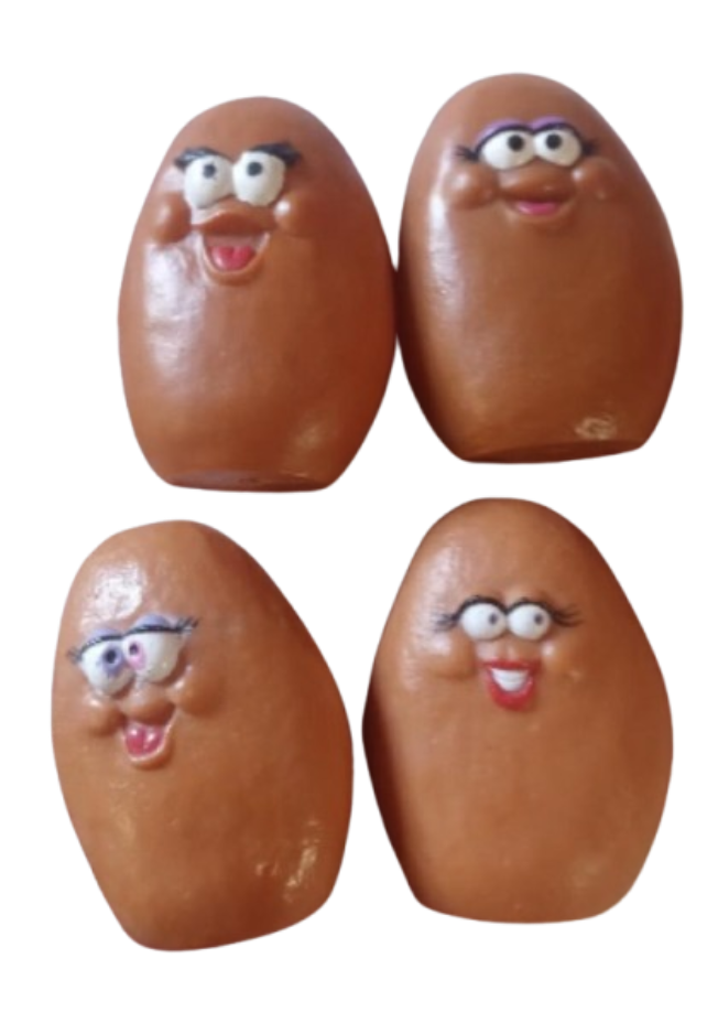 McDonald's McNugget Buddies Figurines Group of four 1980s McDonald's Happy Meal McNugget Buddies hard plastic figures stripped of their snap-on costumes, displaying their bare tan potato-shaped bodies and goofy facial expressions.