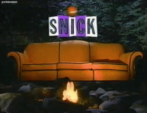 Big Orange Couch sitting in the middle of a dark forest next to a crackling campfire under the glowing SNICK logo.