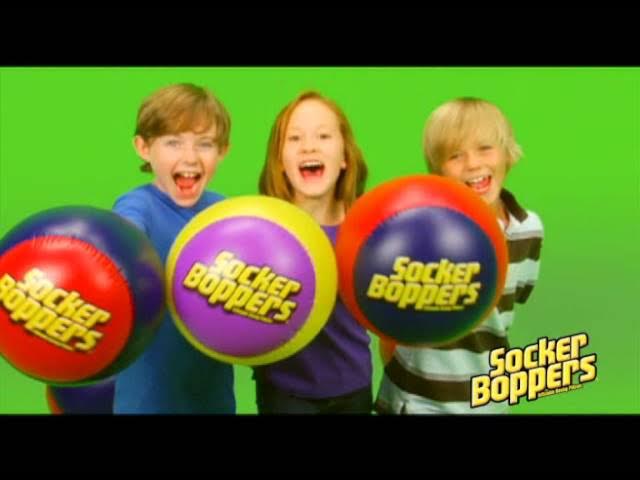 Picture from a classic Socker Boppers commercial featuring three kids grinning and punching inflatable blue, yellow, and red boxing pillows directly toward the camera.