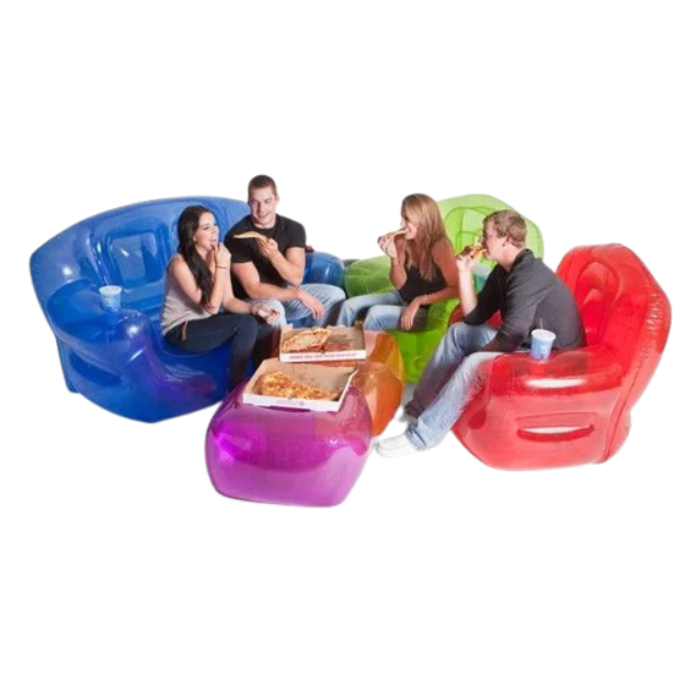 A group of young adults in 90s casualwear eating pizza while lounging on translucent blue, green, red, and purple inflatable blow-up chairs and ottomans set against a plain black background.