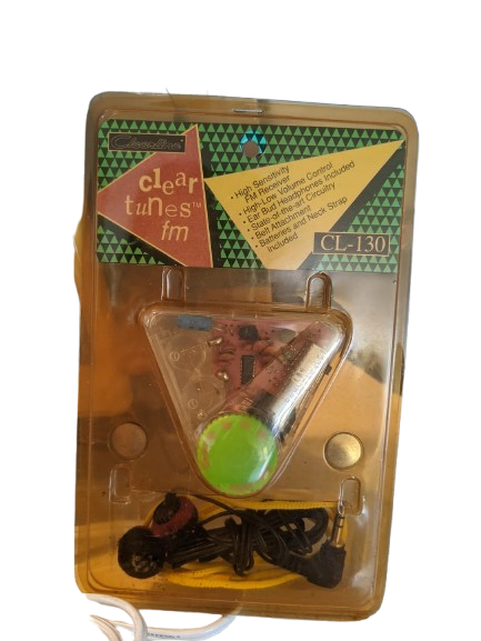 vintage Clear Tunes FM Radio sealed in its original blister pack, displaying its clear triangular receiver body, neon green tuning dial, and black wired earbuds.