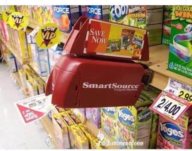A red SmartSource coupon dispenser mounted on a 1990s grocery store shelf, flashing its red light and spitting out paper manufacturer coupons.