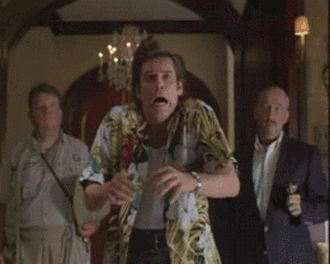 An animated GIF from Ace Ventura: When Nature Calls showing Ace (Jim Carrey) in his Hawaiian shirt doing an over-the-top, panicked slow-motion shimmy and facial routine in a grand hallway.