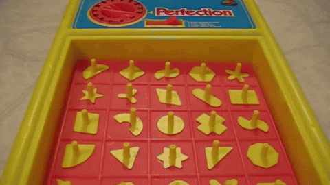 An animated GIF of the Milton Bradley Perfection board game, showing yellow geometric pieces bouncing and popping violently off the red spring-loaded grid as the timer expires.