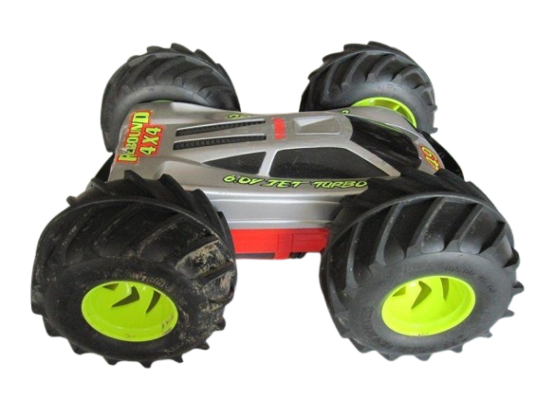 A product photograph of a silver-and-red Tyco Rebound 4x4 radio-controlled stunt truck, featuring oversized treaded monster tires and neon-green rims designed for double-sided flip driving.